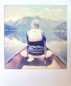 Girl in canoe on lake with mountain in background