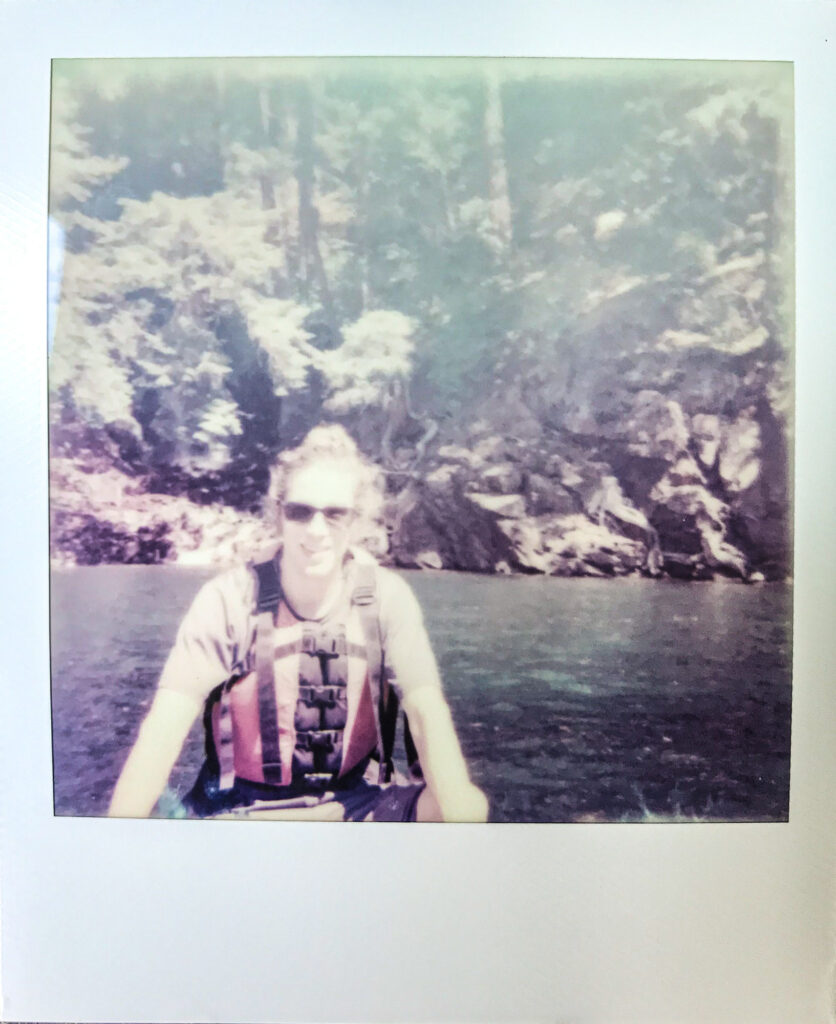 Man in a canoe in front of a waterfall