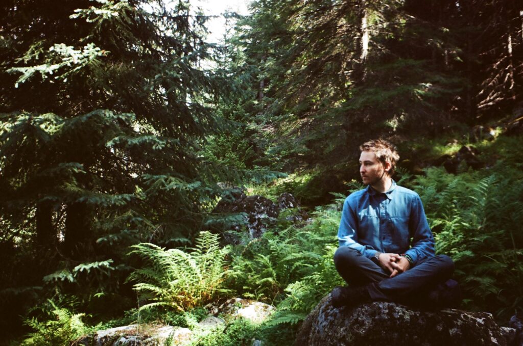 Paul sitting in rock in the woods