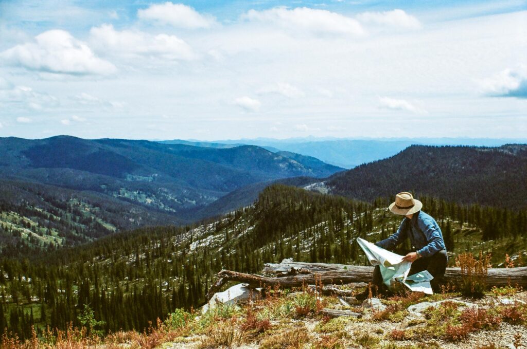 Man with map looking at mountain range