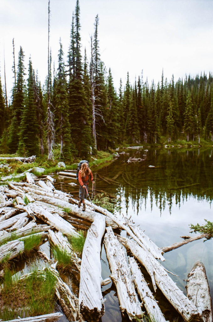 Man crossing water on logs