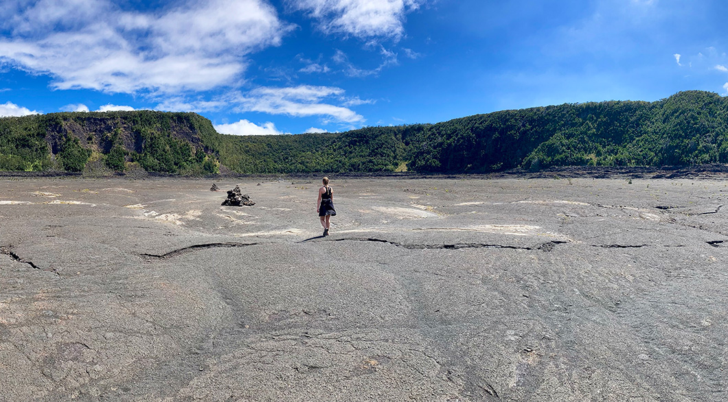 Woman waking on frozen lake of lava rock